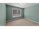 Cozy bedroom with a green accent wall, plush carpet, and a bright window at 104 Vinewood Pl, Holly Springs, NC 27540