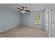 Bright bedroom with a ceiling fan, neutral carpet, and a large window with natural light at 104 Vinewood Pl, Holly Springs, NC 27540