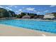 Community pool with lounge chairs, a splash fountain, and a covered gazebo, perfect for summer fun and relaxation at 104 Vinewood Pl, Holly Springs, NC 27540