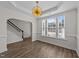 Dining room with modern chandelier, large windows, and staircase at 104 Vinewood Pl, Holly Springs, NC 27540