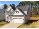 Charming two-story home with a manicured lawn, attached two car garage, and gray siding at 104 Vinewood Pl, Holly Springs, NC 27540