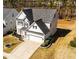 Charming two-story home with gray siding, black shutters, and a well-manicured front yard with an American flag at 104 Vinewood Pl, Holly Springs, NC 27540