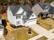 Charming two-story home with gray siding, black shutters, and a well-manicured front yard with an American flag at 104 Vinewood Pl, Holly Springs, NC 27540