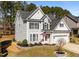 Charming two-story home with gray siding, black shutters, and a well-manicured front yard with an American flag at 104 Vinewood Pl, Holly Springs, NC 27540