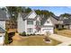 Charming two-story home with gray siding, black shutters, and a well-manicured front yard with an American flag at 104 Vinewood Pl, Holly Springs, NC 27540