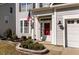Inviting front entrance featuring a red door, an American flag, and landscaped garden beds at 104 Vinewood Pl, Holly Springs, NC 27540