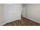 Hallway featuring neutral walls, white doors, and wood-look floors at 104 Vinewood Pl, Holly Springs, NC 27540