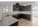 Well-equipped kitchen with granite countertops, stainless steel sink, and dark cabinetry at 104 Vinewood Pl, Holly Springs, NC 27540