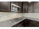 Modern kitchen with granite countertops, stainless steel microwave, and tile backsplash at 104 Vinewood Pl, Holly Springs, NC 27540