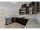 Well-equipped kitchen with granite countertops, dark cabinets, and stainless steel appliances at 104 Vinewood Pl, Holly Springs, NC 27540