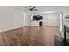 Bright living room with hardwood floors, a fireplace, and an open layout to the kitchen at 104 Vinewood Pl, Holly Springs, NC 27540