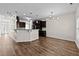 Bright, open-concept living space connecting the kitchen and dining area with hardwood floors at 104 Vinewood Pl, Holly Springs, NC 27540