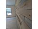 Close-up shows rustic wood accent wall and neutral carpeting by a window at 104 Vinewood Pl, Holly Springs, NC 27540