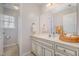 A well-lit bathroom with neutral walls, white cabinets and an attached shower at 1044 S Philwood Ct, Fuquay Varina, NC 27526