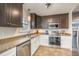 Well-equipped kitchen with stainless steel appliances, tile floors, and a double sink at 1044 S Philwood Ct, Fuquay Varina, NC 27526