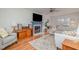 Bright living room featuring a cozy fireplace, ceiling fan, and a comfortable seating area with lots of light at 1044 S Philwood Ct, Fuquay Varina, NC 27526