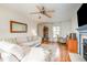 Comfortable living room with hardwood floors, a ceiling fan, and an elegant blue fireplace at 1044 S Philwood Ct, Fuquay Varina, NC 27526