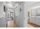 Hallway view with modern lighting, wood floors, and doorways leading to other rooms with a bathroom in view at 1207 Corkery Ridge Ct, Cary, NC 27519