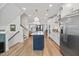 Open kitchen featuring stainless steel appliances, a navy blue island, and access to living and dining areas at 1207 Corkery Ridge Ct, Cary, NC 27519