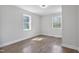 Well-lit bedroom with wood-look flooring, white walls, and two bright windows at 1208 Goldsboro Ave, Sanford, NC 27330