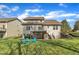 A spacious backyard features a two-story home with a deck and outdoor seating under a bright blue sky at 1416 Endgame Ct, Wake Forest, NC 27587