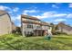 A spacious backyard with a two-story home with a deck and outdoor seating on a sunny day at 1416 Endgame Ct, Wake Forest, NC 27587