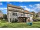 A spacious backyard features a two-story home with a deck and outdoor seating under a bright blue sky at 1416 Endgame Ct, Wake Forest, NC 27587