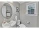 Half bathroom with oval mirror, white vanity, and toilet at 1416 Endgame Ct, Wake Forest, NC 27587