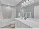 Well-lit bathroom with white vanity, tiled walls, shower-tub combo, and stylish mirror at 1416 Endgame Ct, Wake Forest, NC 27587