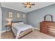 Cozy bedroom with neutral walls, ceiling fan, hardwood bed frame, and dresser at 1416 Endgame Ct, Wake Forest, NC 27587