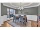 Dining room featuring gray walls, decorative trim, a wooden table, and a modern chandelier at 1416 Endgame Ct, Wake Forest, NC 27587