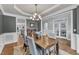 Open dining room featuring a wooden table, modern chandelier, gray walls, and an open layout at 1416 Endgame Ct, Wake Forest, NC 27587