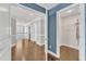 Hallway featuring hardwood floors, white trim, and open access to a separate landing and bedroom at 1416 Endgame Ct, Wake Forest, NC 27587