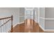 Open hallway with hardwood floors, white trim, and a view of the stairway at 1416 Endgame Ct, Wake Forest, NC 27587