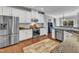Bright kitchen with stainless steel appliances, granite countertops, and hardwood floors with a rug at 1416 Endgame Ct, Wake Forest, NC 27587