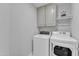 Functional laundry room featuring modern washer and dryer units and overhead cabinetry at 1416 Endgame Ct, Wake Forest, NC 27587