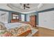 Comfortable main bedroom featuring hardwood floors, a tray ceiling with a ceiling fan, and wooden furniture at 1416 Endgame Ct, Wake Forest, NC 27587