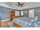 Comfortable main bedroom featuring hardwood floors, a tray ceiling with a ceiling fan, and blue accent walls at 1416 Endgame Ct, Wake Forest, NC 27587