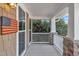 Cozy porch area with decorative stone supports, ample light, and American flag detail at 1416 Endgame Ct, Wake Forest, NC 27587