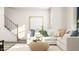Inviting living room features a comfortable white sectional, textured ottoman, and neutral decor accents at 1755 Barrett Run Trl # 213, Apex, NC 27502