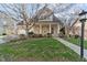 Charming brick home featuring a columned front porch and manicured landscaping at 1818 Buxton Way, Burlington, NC 27215