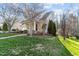 Beautifully landscaped front yard with blooming trees, complementing the home's facade at 1818 Buxton Way, Burlington, NC 27215