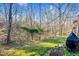 A tree-filled backyard with a grill at 198 Ridge Trl, Chapel Hill, NC 27516