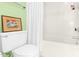 Bathroom with white toilet and bathtub, framed art, shower curtain, and green accent wall at 198 Ridge Trl, Chapel Hill, NC 27516