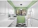 Bright kitchen with white cabinets and appliances, lots of natural light, and vintage checkerboard flooring at 198 Ridge Trl, Chapel Hill, NC 27516