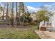 Backyard with a wood fence, mature trees, and a small deck, offering privacy and outdoor enjoyment at 2010 Blanchard St, Apex, NC 27502