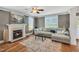 Cozy living room featuring a fireplace, large windows, hardwood floors, and a comfortable seating area at 2015 Stanchion St, Haw River, NC 27258