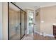 Bathroom featuring glass shower with built-in seat, light brown tiling, and open doorway at 2015 Stanchion St, Haw River, NC 27258