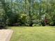 Backyard featuring lush green lawn and mature landscaping at 2046 Fellini Dr, Apex, NC 27502