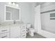 Clean, bright bathroom featuring a granite vanity and a shower-tub with decorative tile accents at 2046 Fellini Dr, Apex, NC 27502